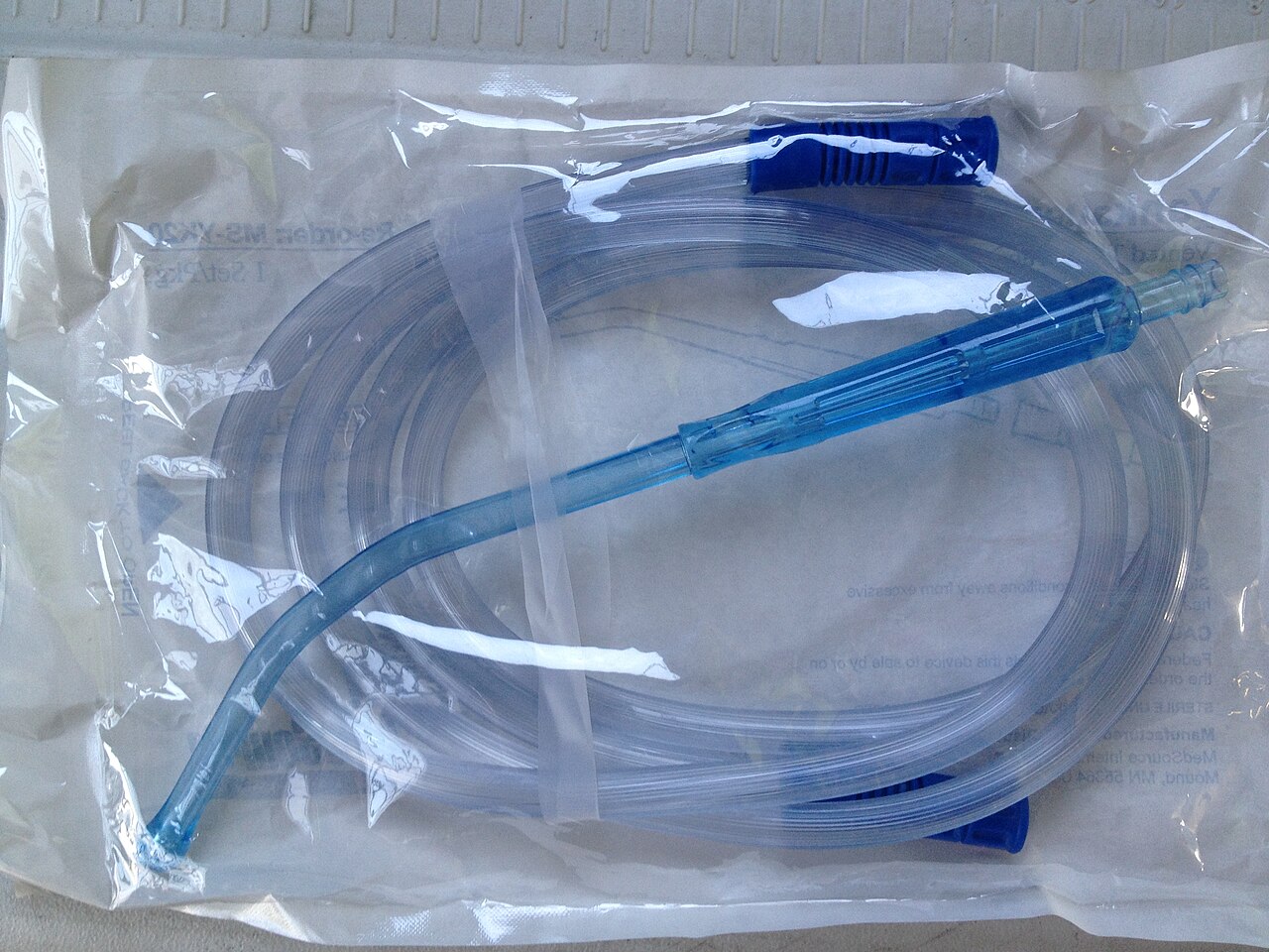 Rigid curved Yankauer suction tip packaged with suction tubing