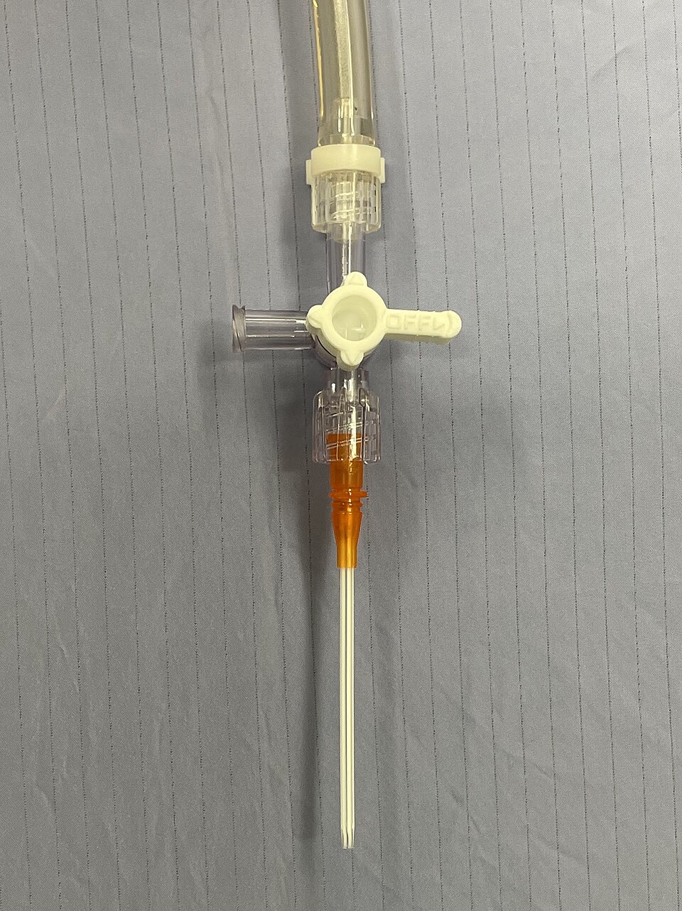 Narrow-bore orange catheter on a three-way stopcock with a short clear tube above it