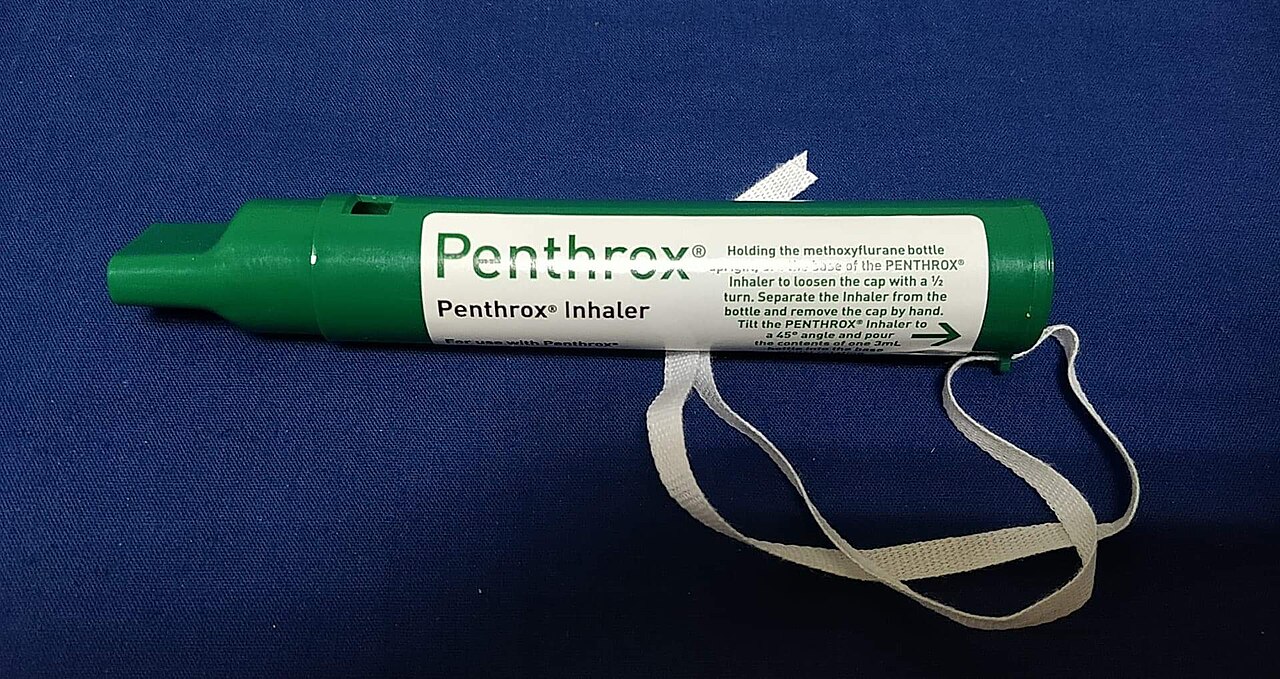 Green Penthrox handheld inhaler with mouthpiece, printed loading instructions and white wrist loop